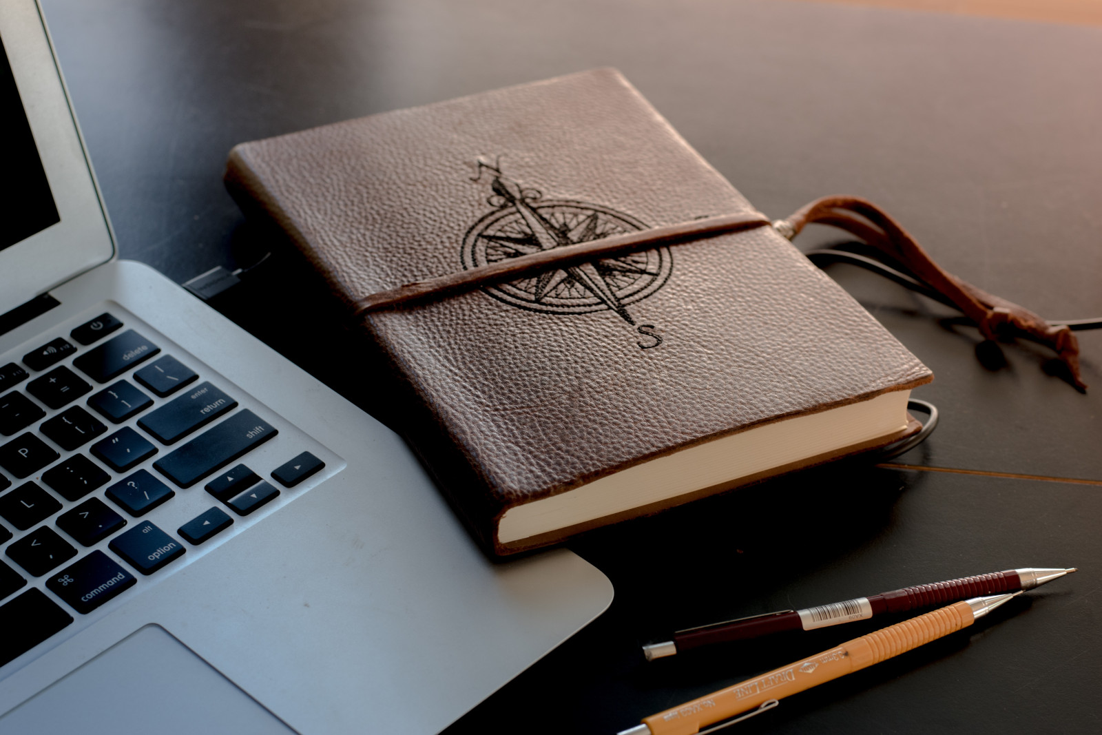 Laptop and journal with compass on the front