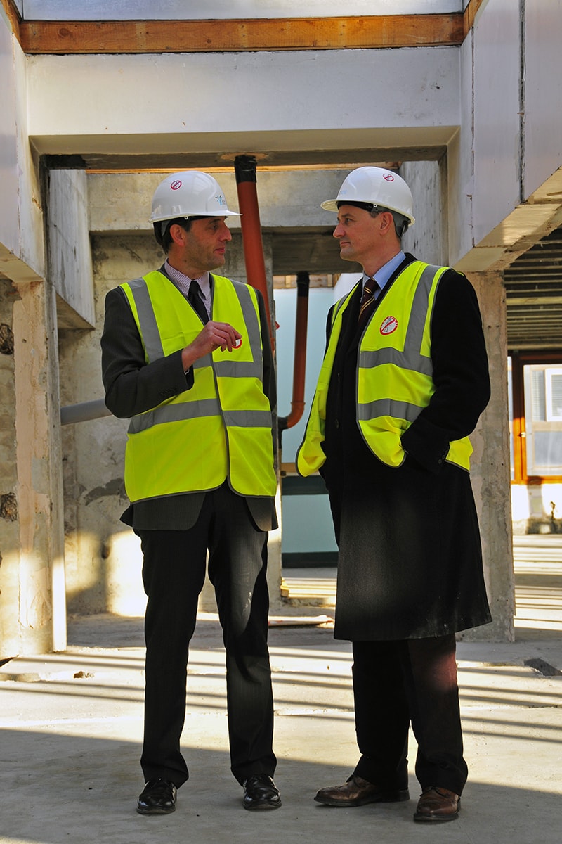 Nick Oliver standing with colleague in front of the then new Business School building