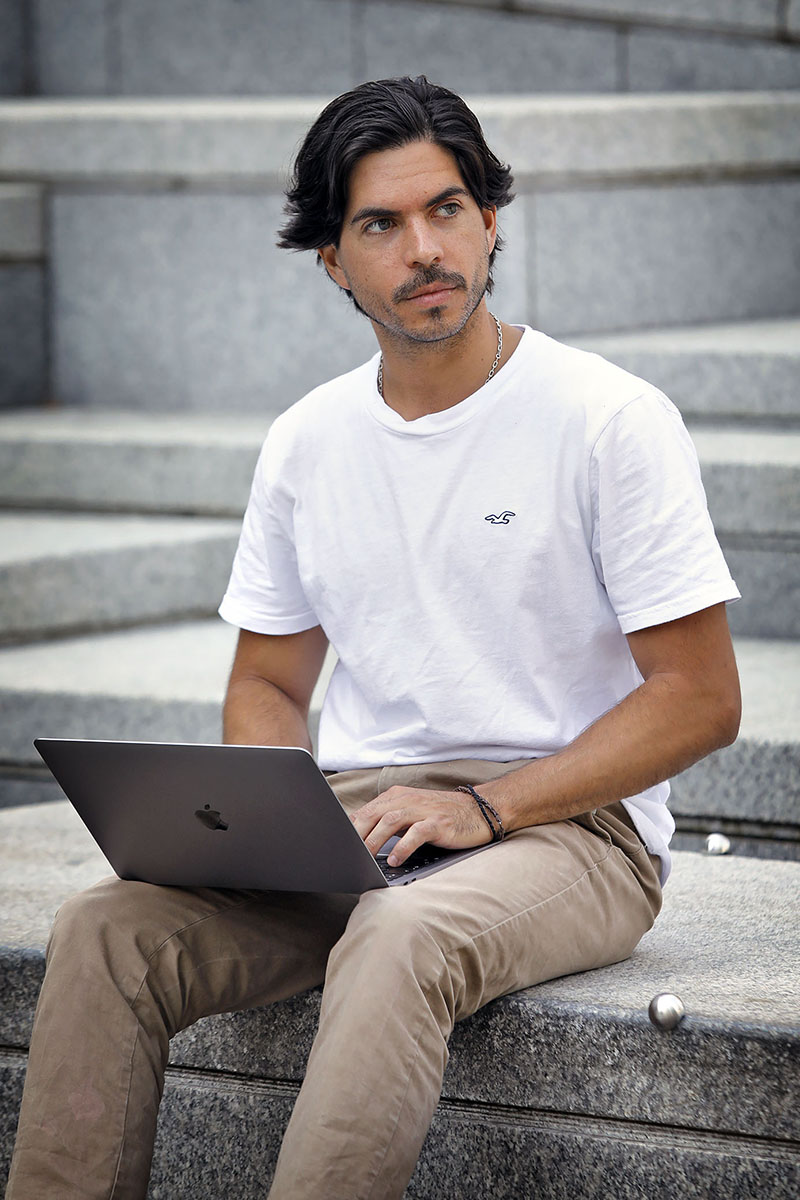 MBA student sitting outside with a laptop