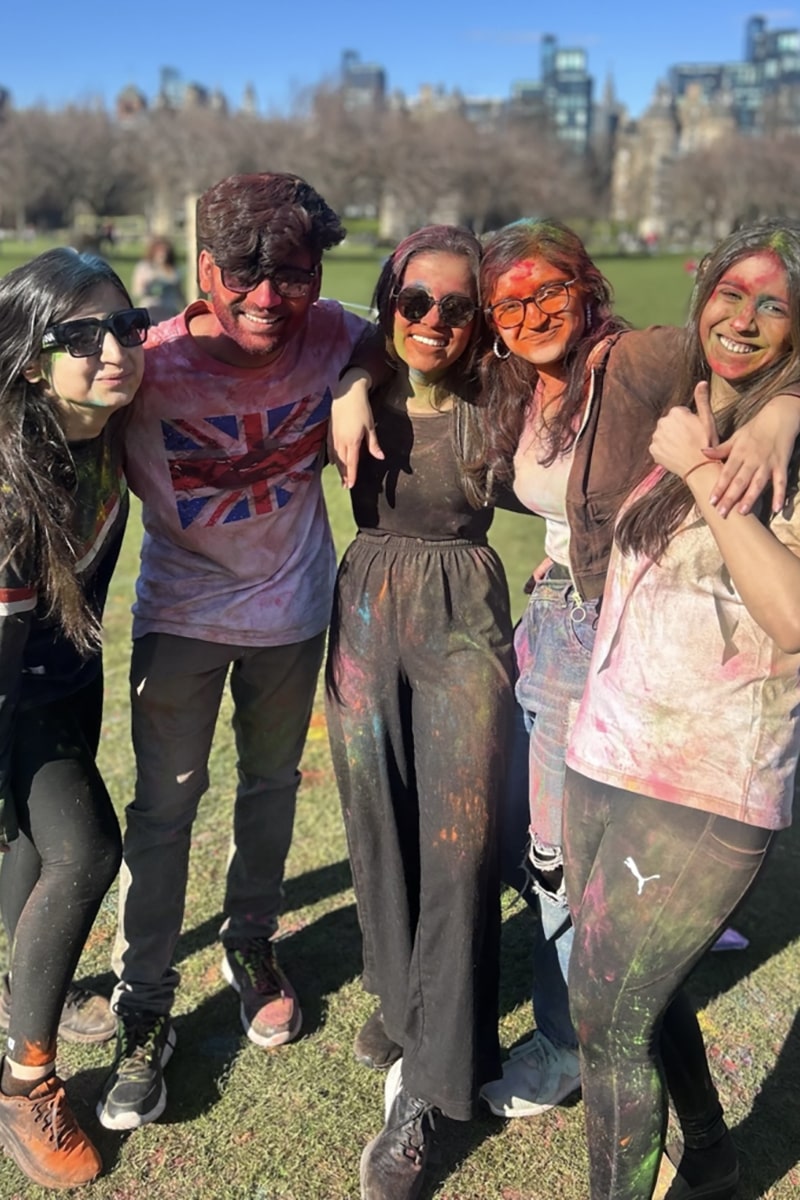 Pranshi and four friends standing in The Meadows covered in coloured powder celebrating Holi