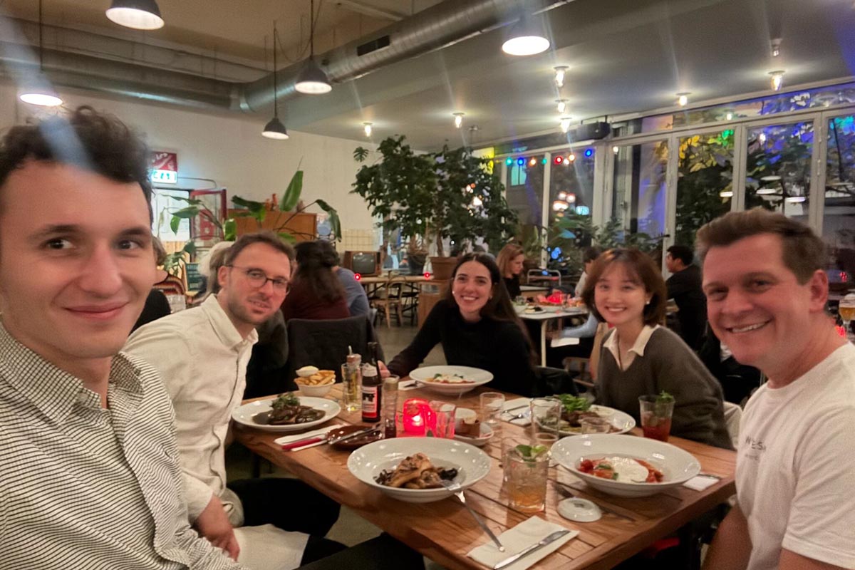 Group of people having dinner around a table