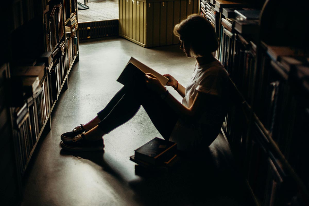 person sitting on library floor studying