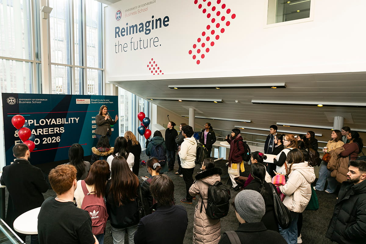 About 25 Employability and Careers Expo attendees standing in the University of Edinburgh Business School concourse