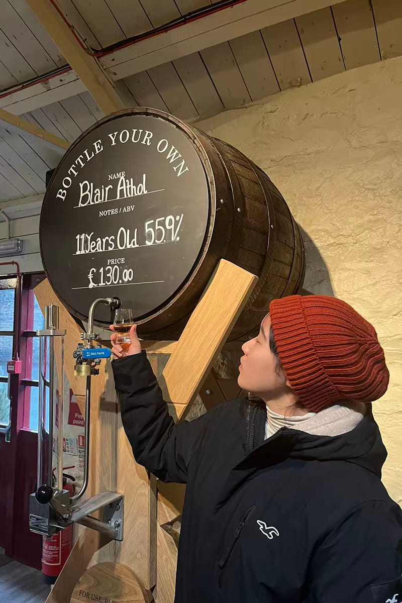 Student pouring drink from keg at Blair Atholl Distillery