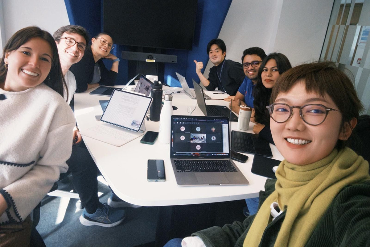 Group of students sitting at a table with their laptops