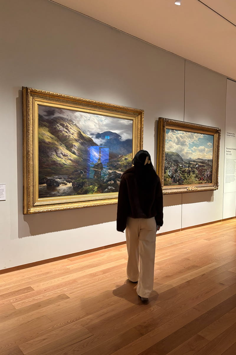 Student standing looking at portraits in the National Galleries of Scotland (NGS) 
