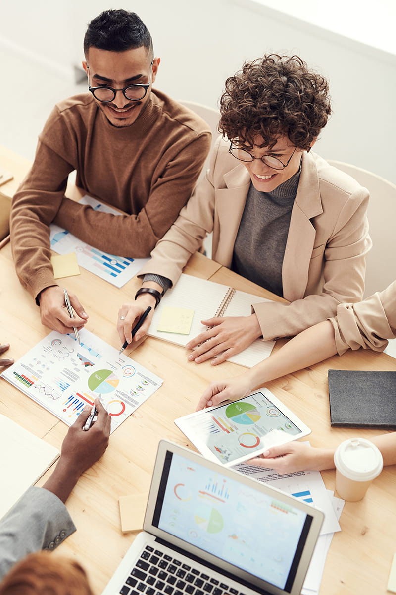 A group of business people sitting around a desk looking at documents