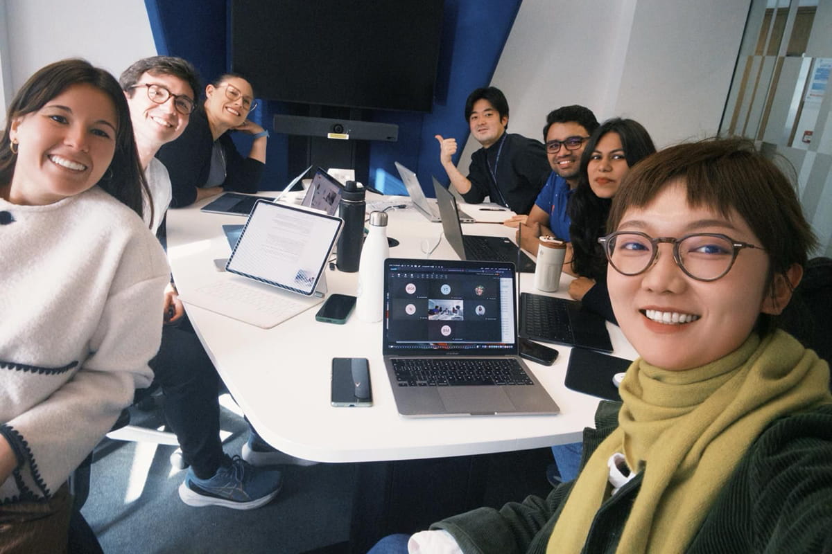 Group of students sitting at a table with their laptops