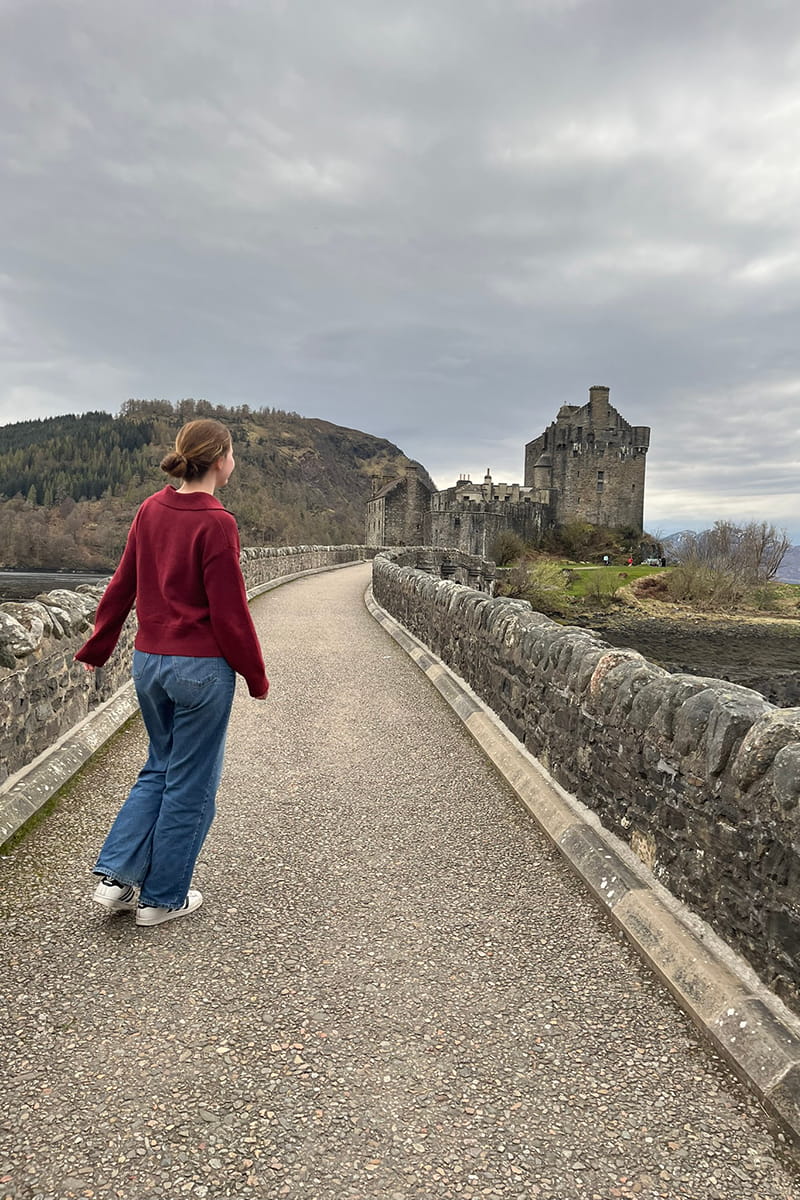 MSc student walking towards Eilean Donan Castle