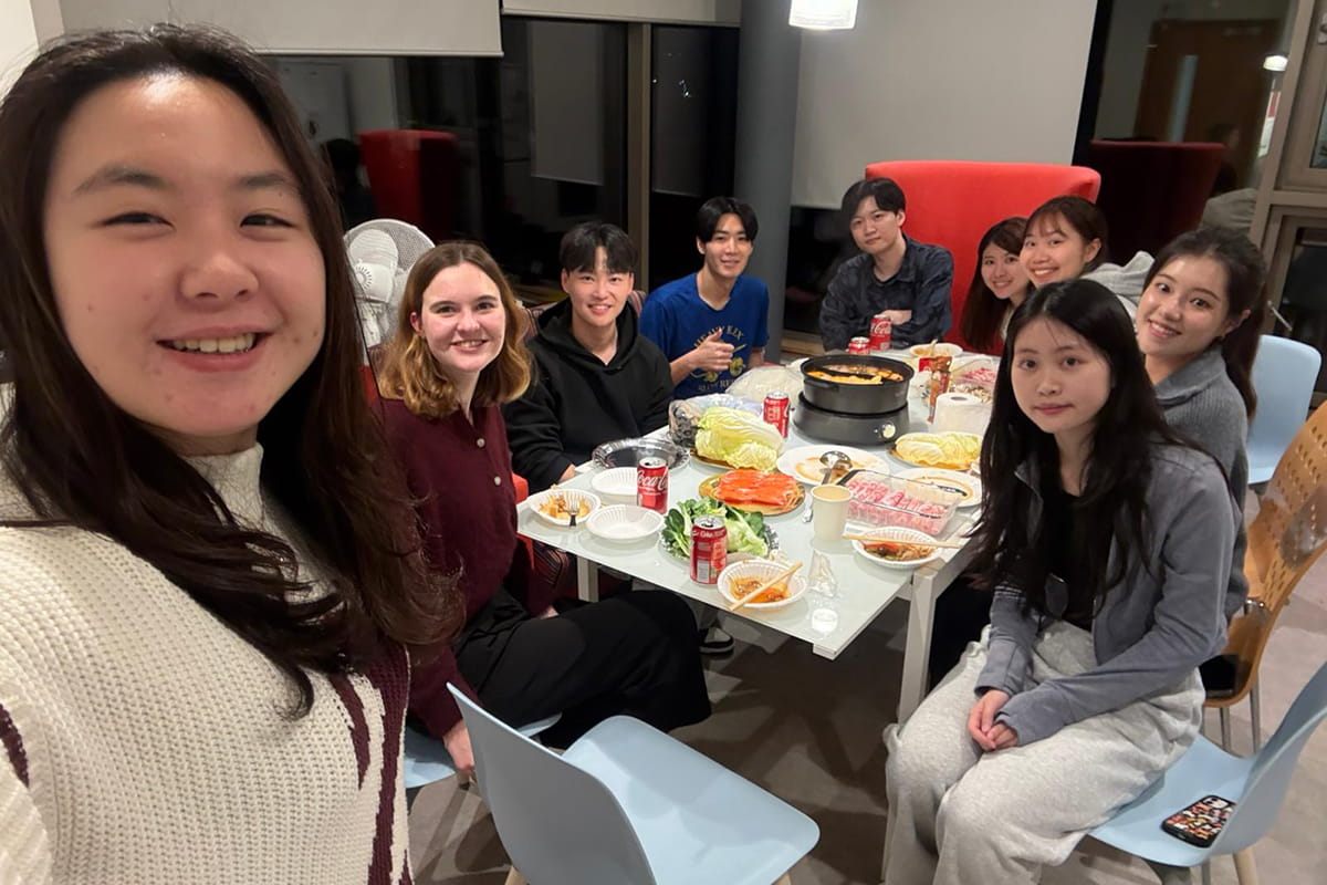 Nine MSc students gathered around a table for a meal