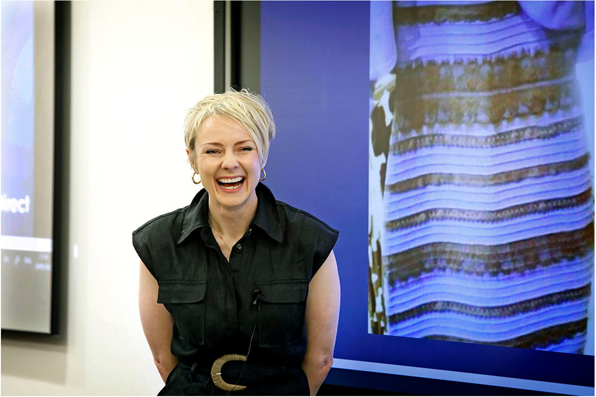 Smiling woman standing in front of a screen