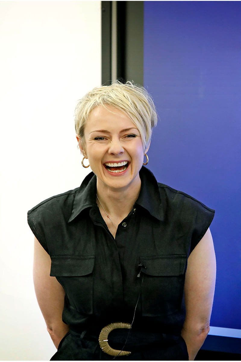 Smiling woman standing in front of a screen