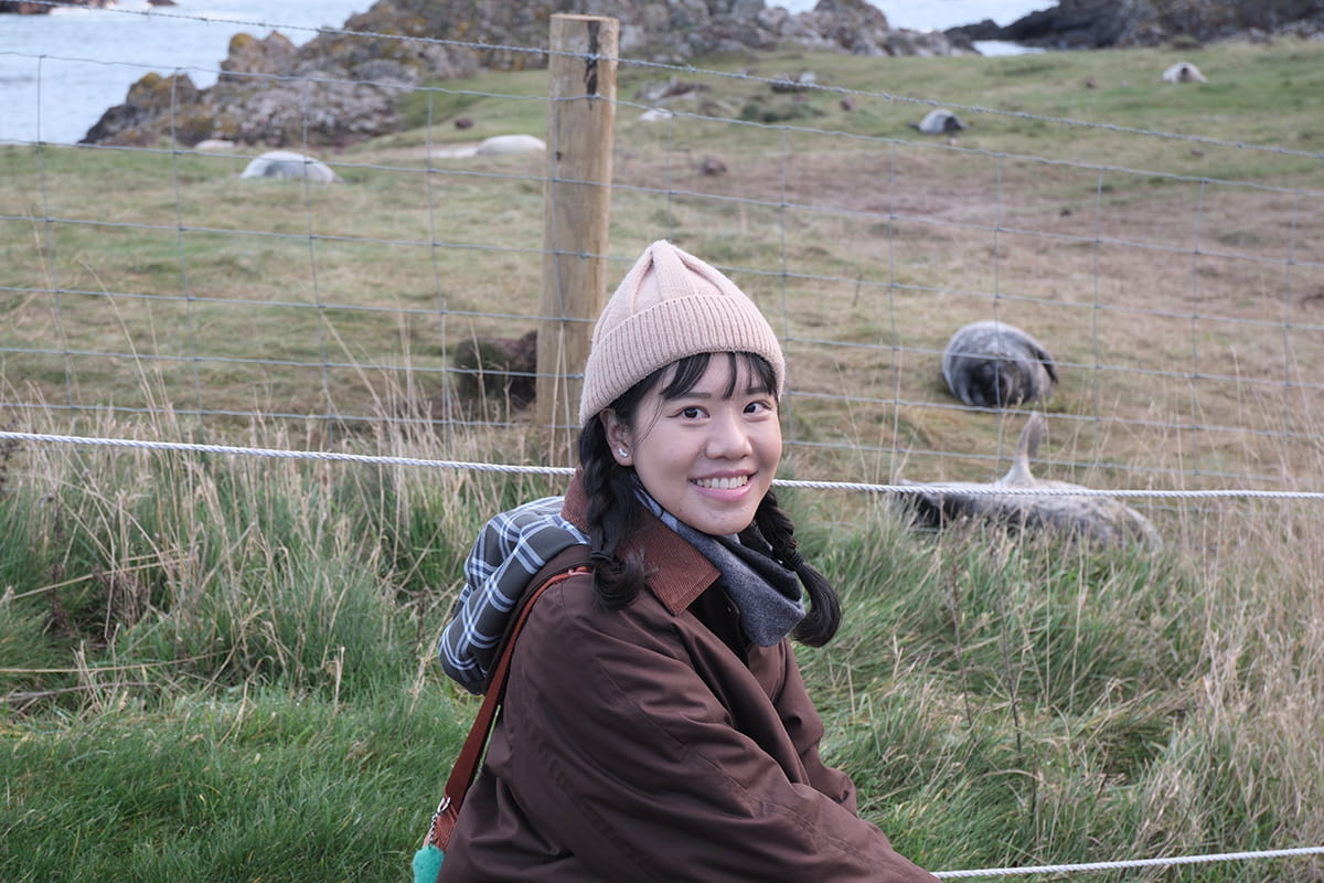 MSc student pictured in front of seals at the coastal village of St Abbs