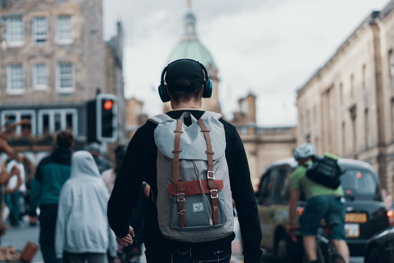 Man walking with headphones and backpack on George IV Street, Edinburgh