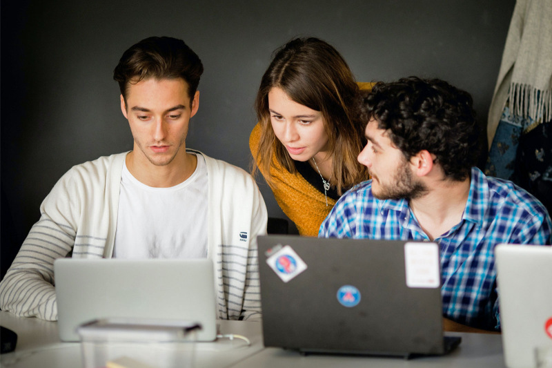 Group of students looking at laptops