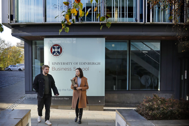 Two students walking in front of the Business School building