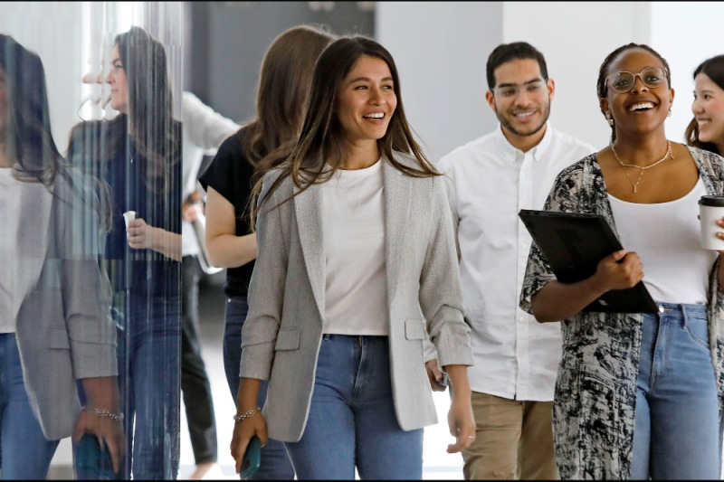 Group of diverse students pictured smiling as they walk through the University of Edinburgh Business School