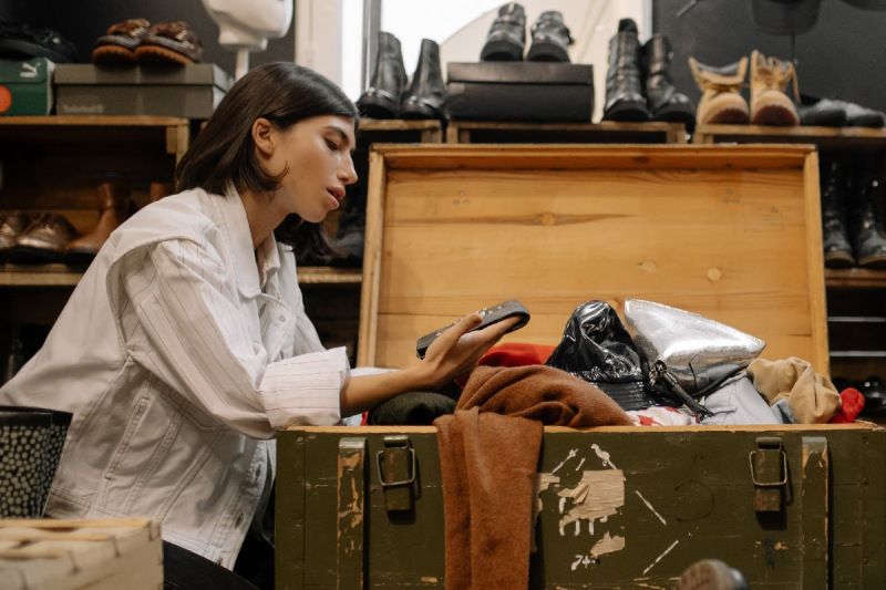 Woman looking through trunk of clothes