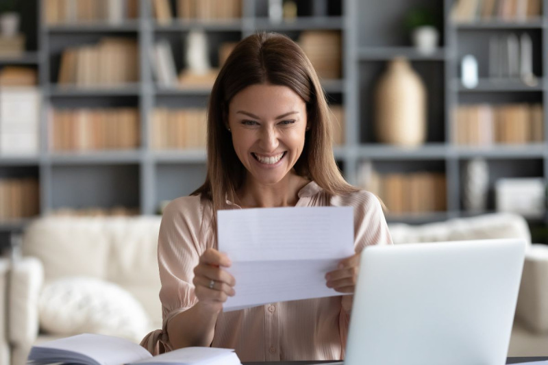 Photo of woman smiling reading a letter