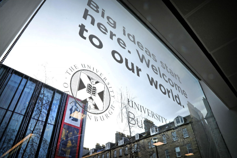 Photo of the entrance to the University of Edinburgh Business School with a large quote visible in the glass window.