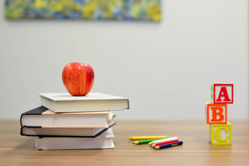 Books and apple on desk