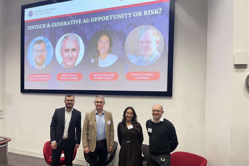 Panel members standing at the front of the auditorium