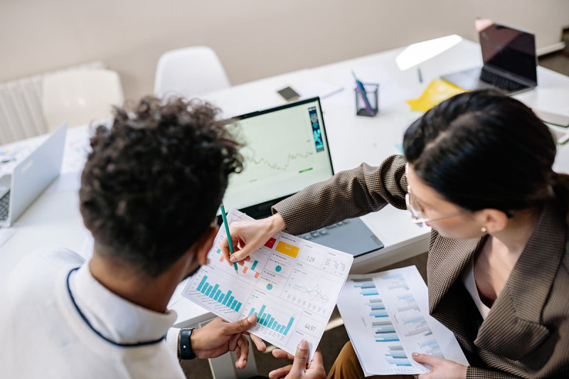 Two colleagues analysing data together at a desk
