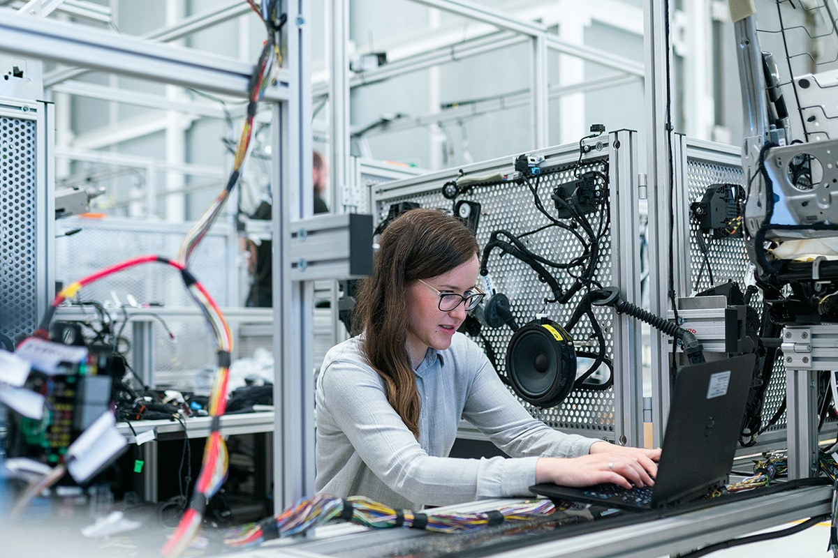 Engineer working on a laptop in a car manufacturing factory