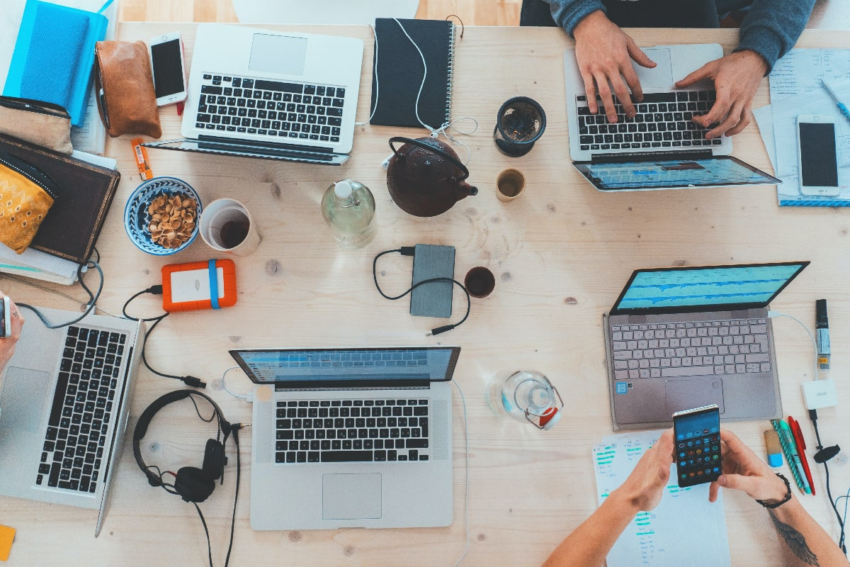 Birds-eye view of a table of people working on screens