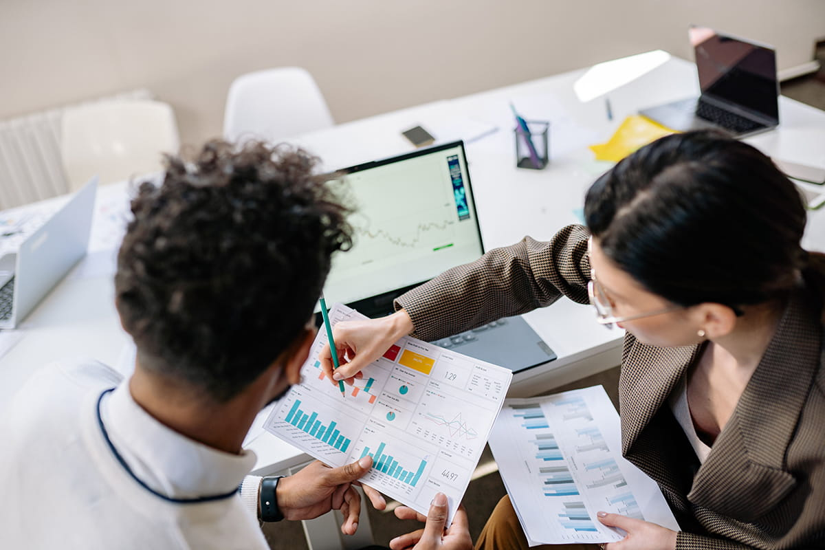 Two colleagues analysing data together at a desk