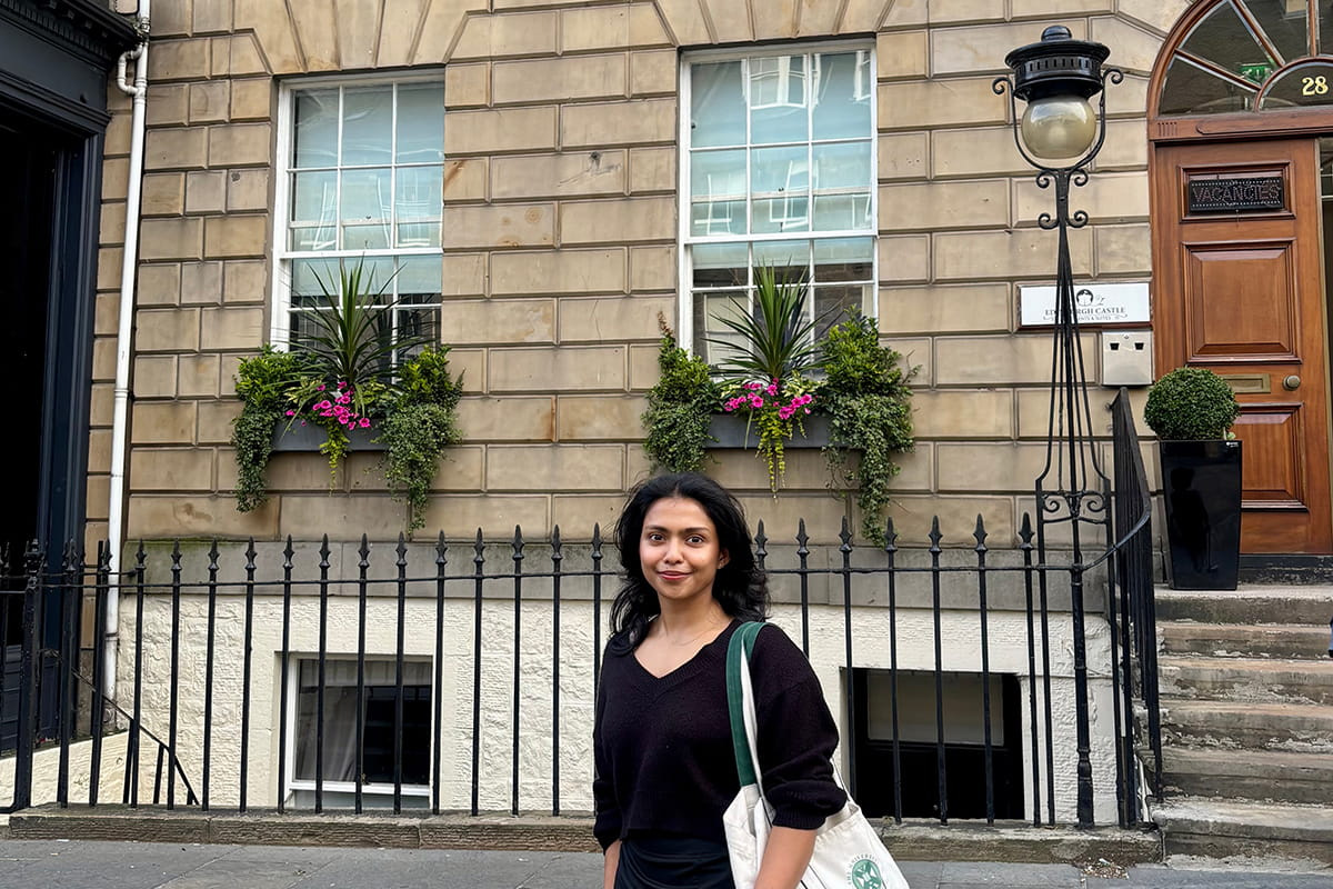 MSc Entrepreneurship and Innovation student  standing on a street in Edinburgh in front of railings