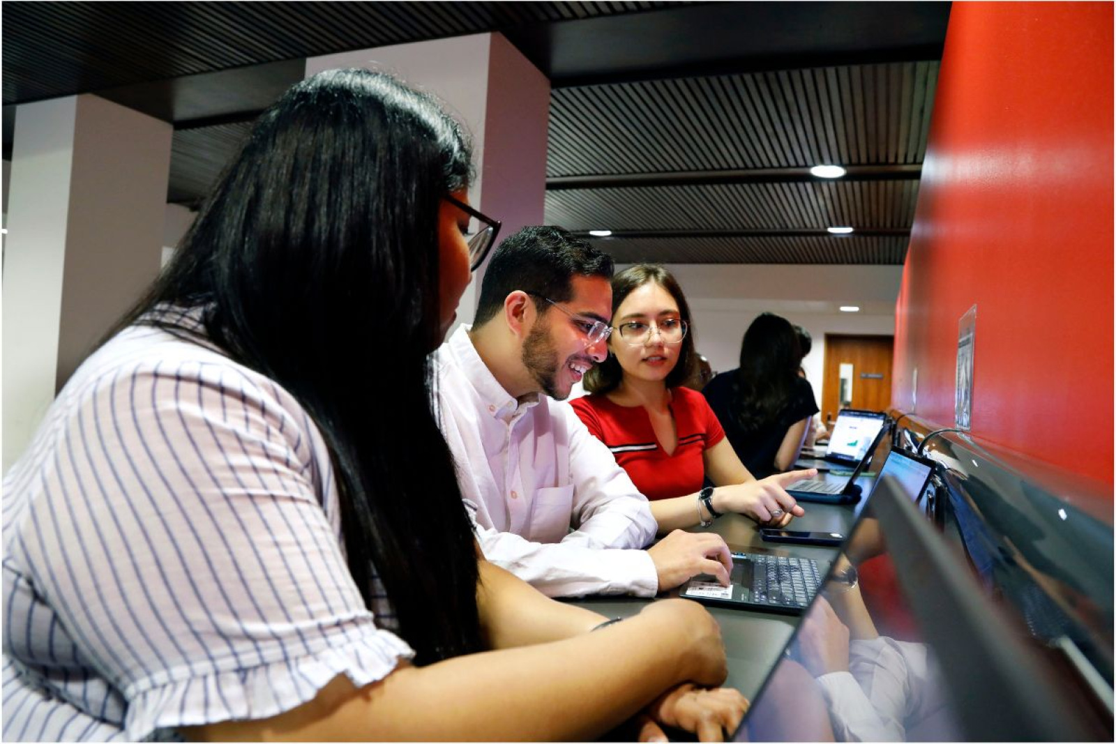 3 postgraduate students studying with laptops at the University of Edinburgh Business School